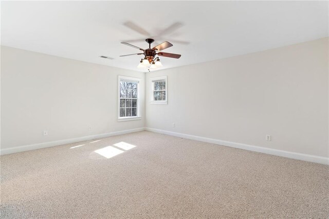spare room featuring baseboards, ceiling fan, and light carpet