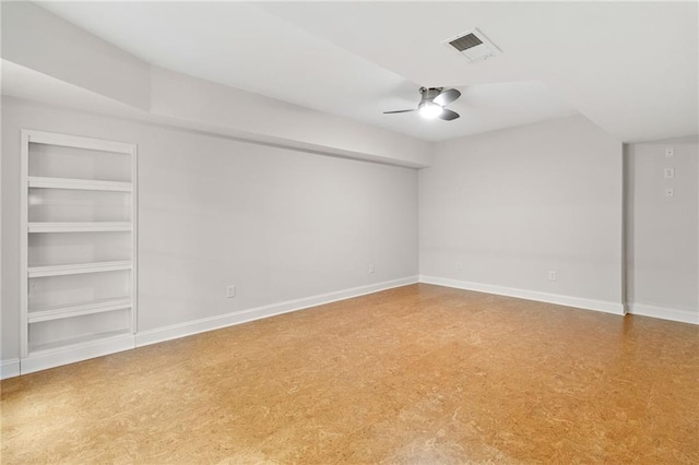 empty room with built in features, visible vents, baseboards, and a ceiling fan