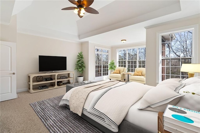 carpeted bedroom featuring ceiling fan, ornamental molding, and a raised ceiling