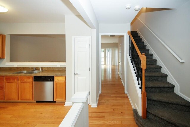 kitchen featuring sink, dishwasher, and light hardwood / wood-style floors