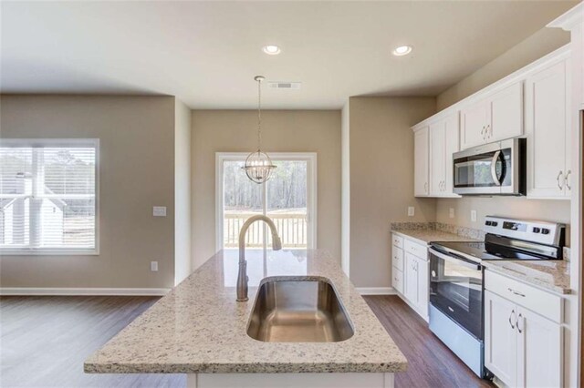 kitchen featuring sink, a healthy amount of sunlight, a center island with sink, and appliances with stainless steel finishes