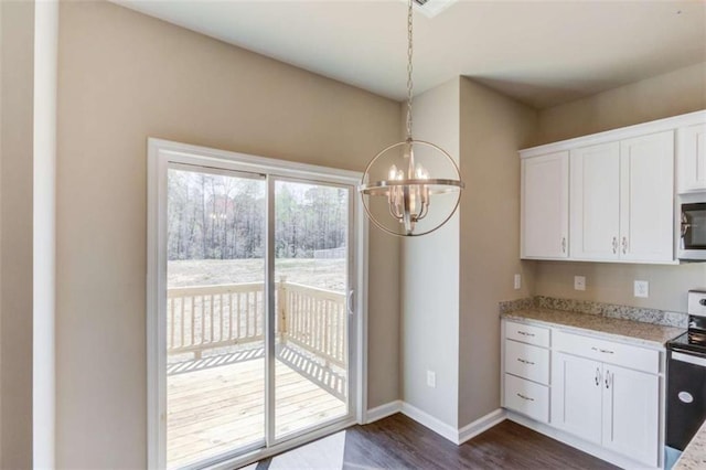 kitchen featuring decorative light fixtures, dark hardwood / wood-style floors, white cabinetry, and appliances with stainless steel finishes