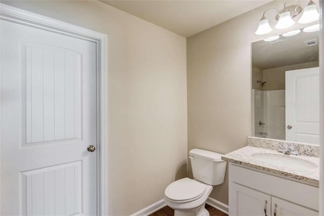 bathroom featuring a shower, vanity, and toilet