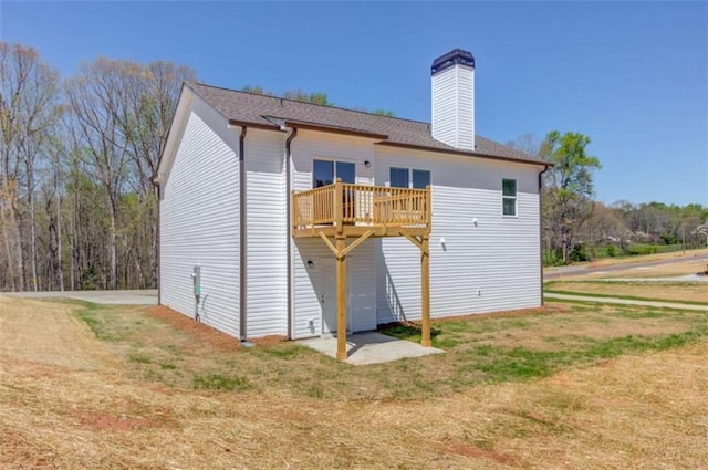 rear view of house with a wooden deck and a lawn