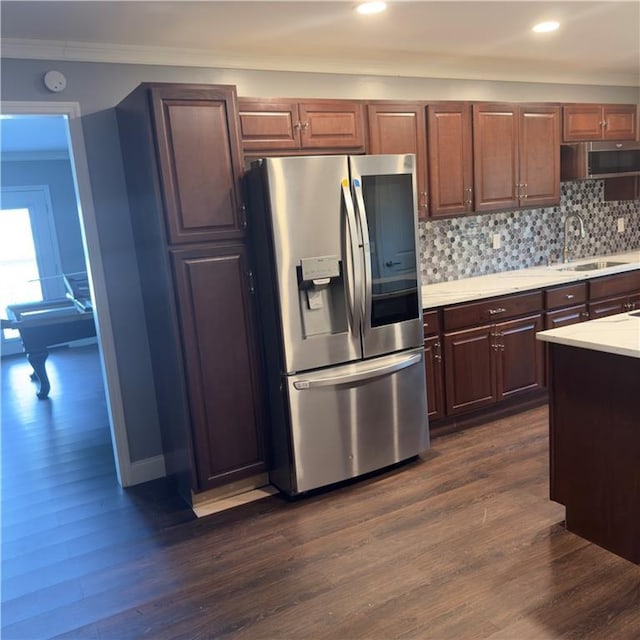 kitchen with stainless steel appliances, dark wood-style flooring, light countertops, and a sink