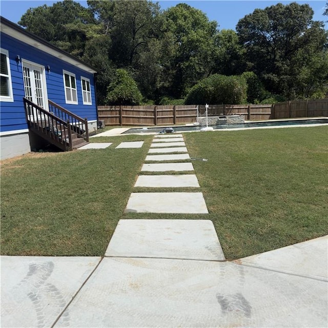 view of yard with entry steps and a fenced backyard