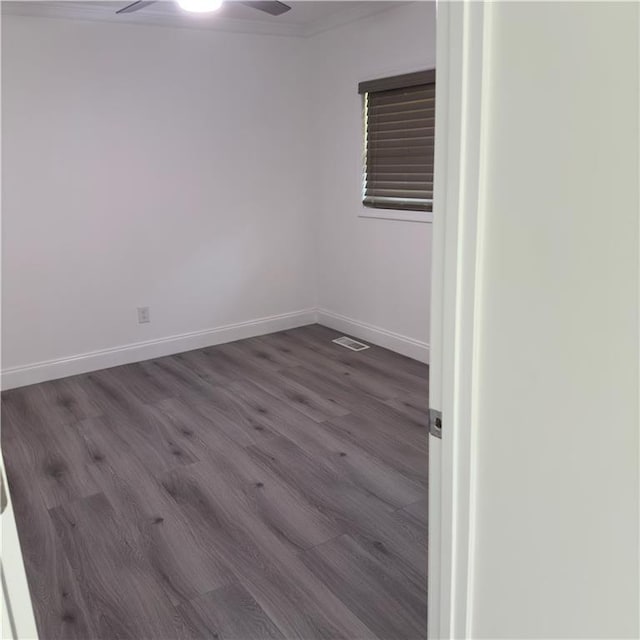 unfurnished room with visible vents, a ceiling fan, ornamental molding, wood finished floors, and baseboards