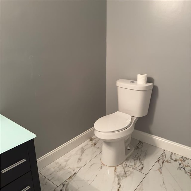 bathroom featuring marble finish floor, toilet, vanity, and baseboards