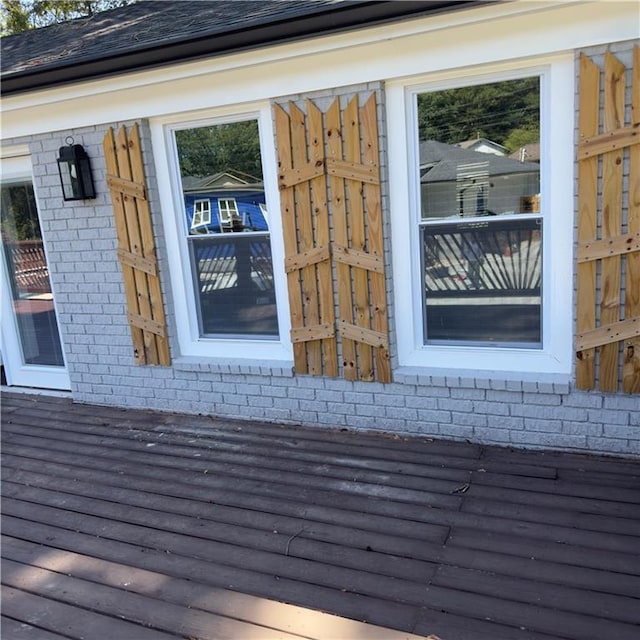 exterior details with a shingled roof and brick siding