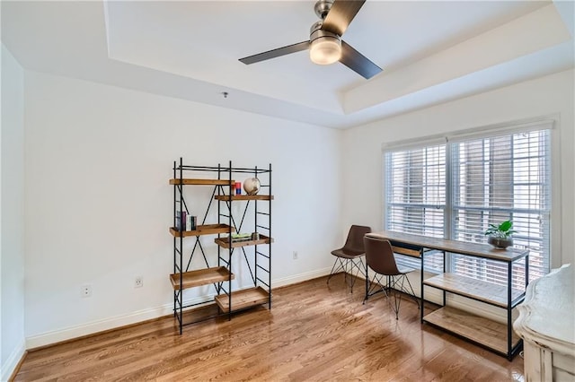 sitting room featuring hardwood / wood-style floors, ceiling fan, and a tray ceiling