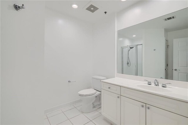 bathroom with tile patterned floors, vanity, toilet, and walk in shower