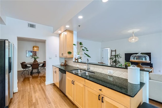 kitchen with sink, appliances with stainless steel finishes, light brown cabinetry, and pendant lighting