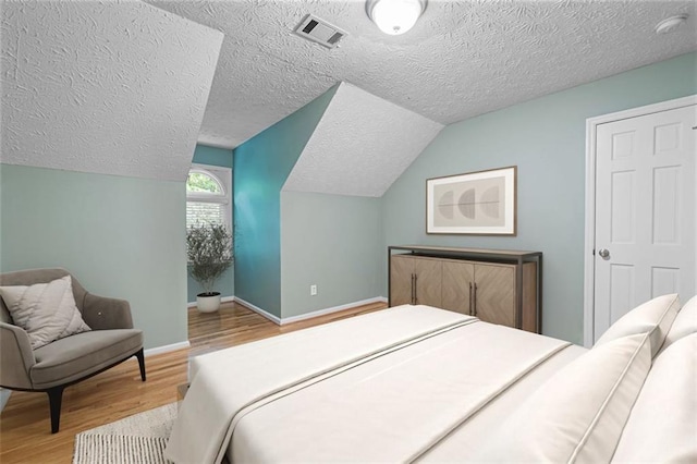 465 Willowbrook Dr SE, Smyrna, GA 30082 - bedroom featuring wood finished floors, a textured ceiling, vaulted ceiling, and baseboards