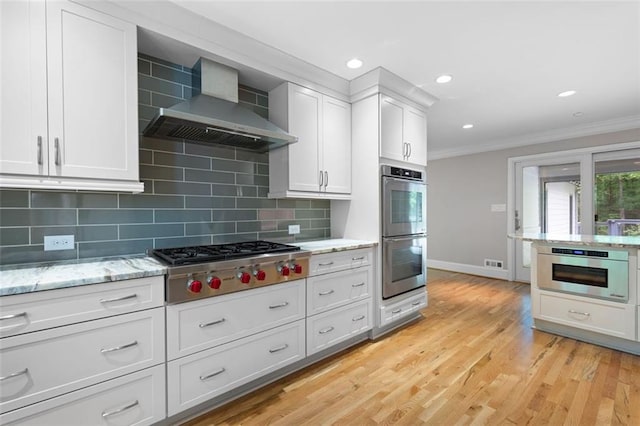 465 Willowbrook Dr SE, Smyrna, GA 30082 - kitchen with wall chimney exhaust hood, appliances with stainless steel finishes, crown molding, baseboards, and backsplash