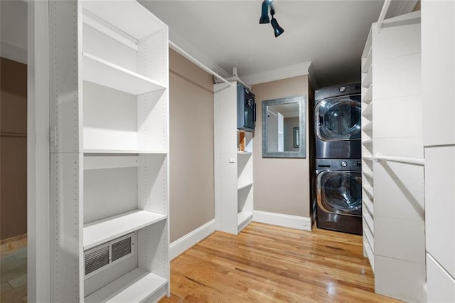 465 Willowbrook Dr SE, Smyrna, GA 30082 - laundry area featuring stacked washing machine and dryer, light wood-style floors, baseboards, and crown molding