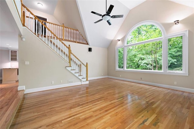 465 Willowbrook Dr SE, Smyrna, GA 30082 - unfurnished living room featuring light wood finished floors, ceiling fan, stairway, high vaulted ceiling, and baseboards
