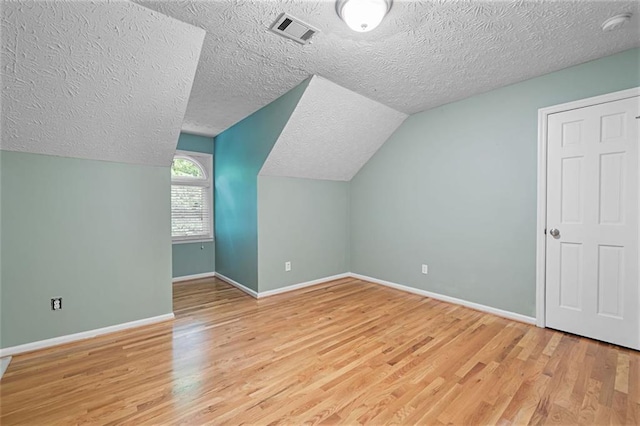 465 Willowbrook Dr SE, Smyrna, GA 30082 - additional living space with a textured ceiling, light wood-type flooring, baseboards, and vaulted ceiling
