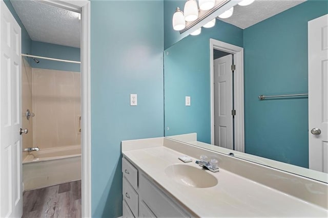 465 Willowbrook Dr SE, Smyrna, GA 30082 - bathroom with a textured ceiling, wood finished floors, vanity, and shower / bathtub combination