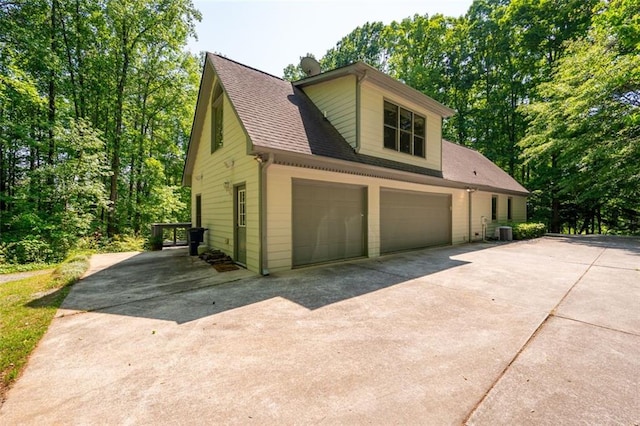 465 Willowbrook Dr SE, Smyrna, GA 30082 - view of home's exterior featuring concrete driveway, roof with shingles, cooling unit, and a garage