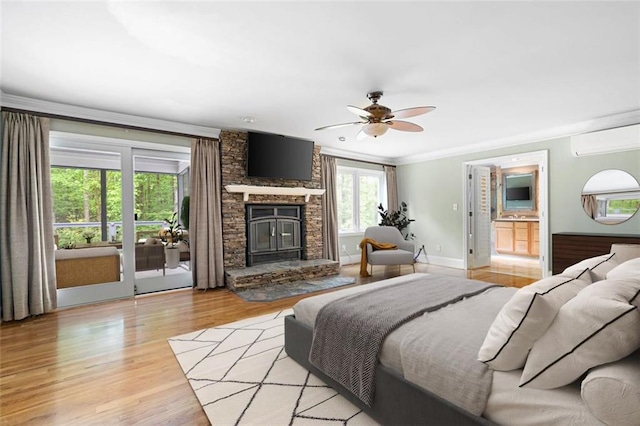 465 Willowbrook Dr SE, Smyrna, GA 30082 - bedroom featuring an AC wall unit, a stone fireplace, light wood-style flooring, access to outside, and baseboards