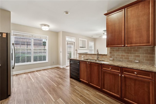 kitchen featuring light stone countertops, dishwasher, sink, stainless steel refrigerator with ice dispenser, and light hardwood / wood-style floors