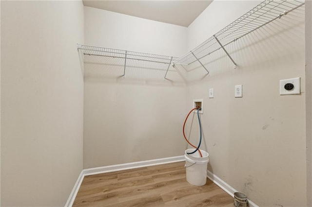 clothes washing area featuring hardwood / wood-style flooring, washer hookup, and hookup for an electric dryer