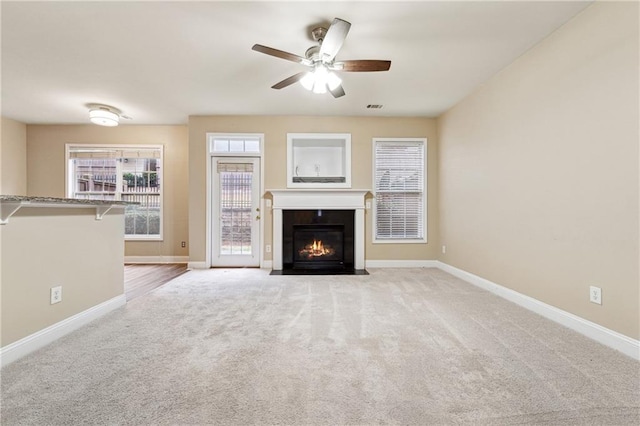 unfurnished living room with ceiling fan and light carpet