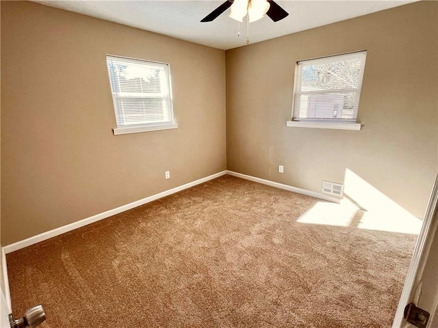 carpeted spare room with ceiling fan and a healthy amount of sunlight