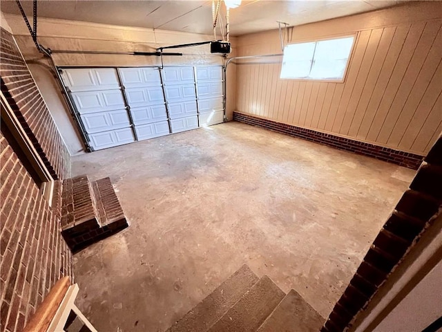 garage featuring wooden walls and a garage door opener