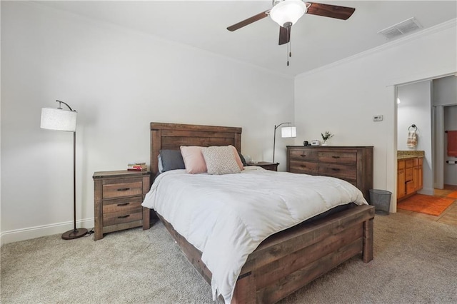 bedroom with ceiling fan, ornamental molding, ensuite bathroom, and light carpet