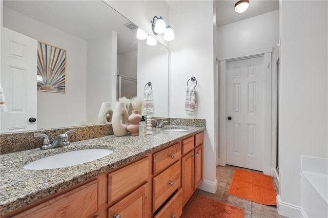 bathroom with tile patterned flooring, vanity, and walk in shower