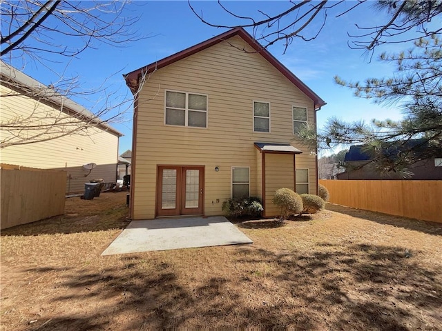 rear view of house with a fenced backyard and a patio