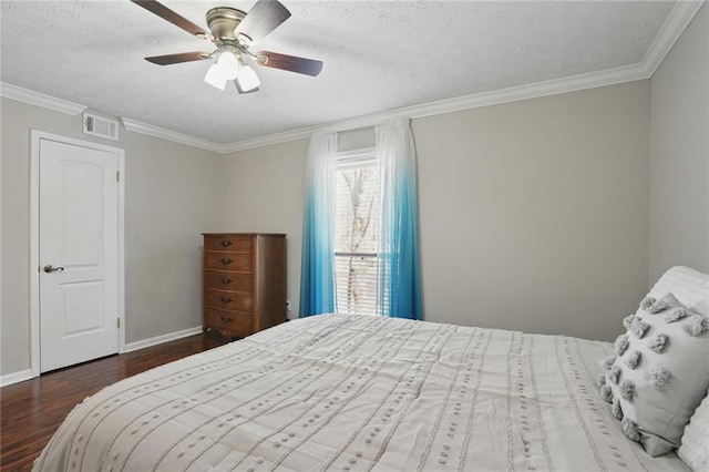 bedroom featuring visible vents, baseboards, ornamental molding, wood finished floors, and a textured ceiling