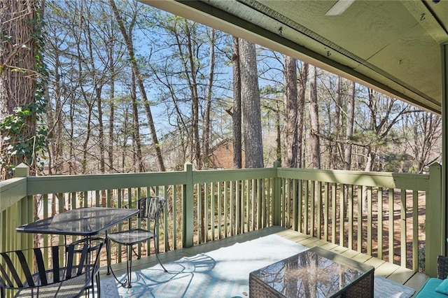 wooden deck featuring outdoor dining space and ceiling fan