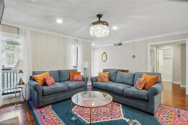 living area featuring wood finished floors, visible vents, a wealth of natural light, and a textured ceiling