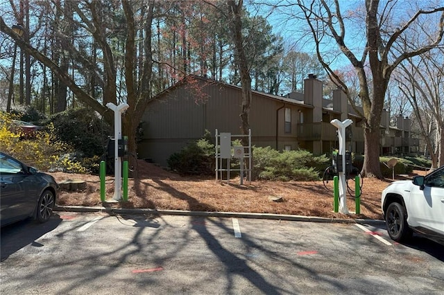 view of front of property featuring uncovered parking and a chimney