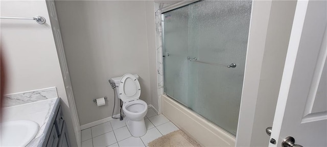 bathroom with tile patterned floors, toilet, combined bath / shower with glass door, baseboards, and vanity