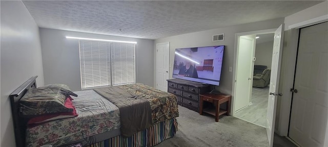 carpeted bedroom with visible vents and a textured ceiling