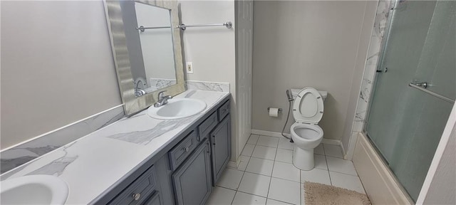 bathroom featuring toilet, tile patterned flooring, baseboards, bath / shower combo with glass door, and vanity