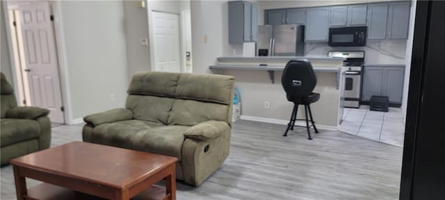 living area with baseboards and light wood finished floors