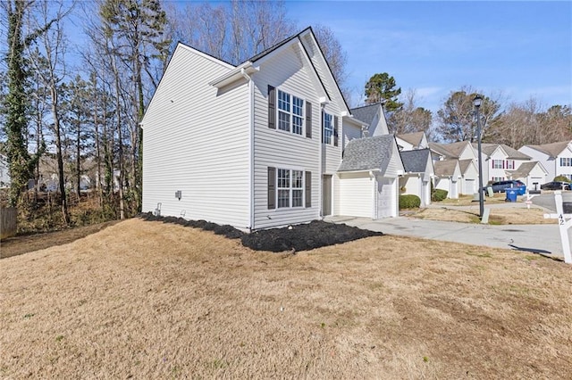 view of home's exterior with concrete driveway, a lawn, and a residential view