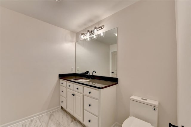 half bathroom with toilet, baseboards, marble finish floor, and vanity