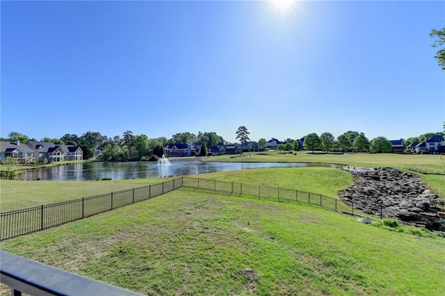 view of yard with a water view, fence, and a residential view
