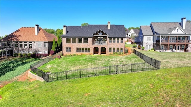 back of house with a lawn, fence, and a balcony