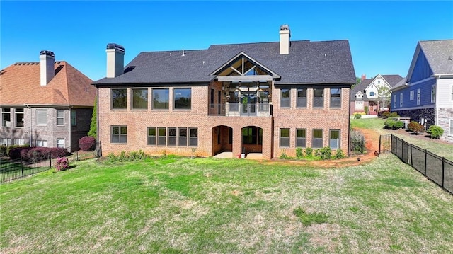 rear view of house with a lawn, brick siding, and fence