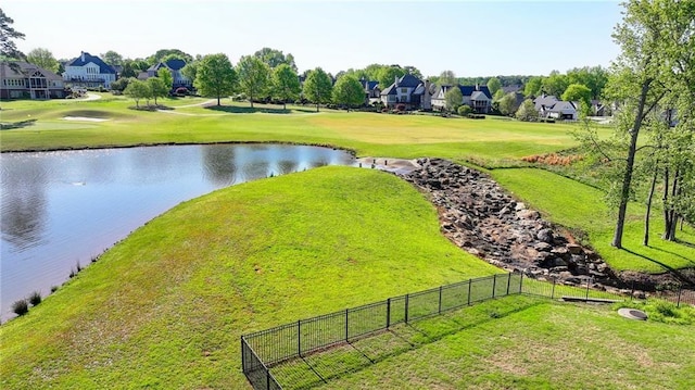 drone / aerial view with a water view, view of golf course, and a residential view