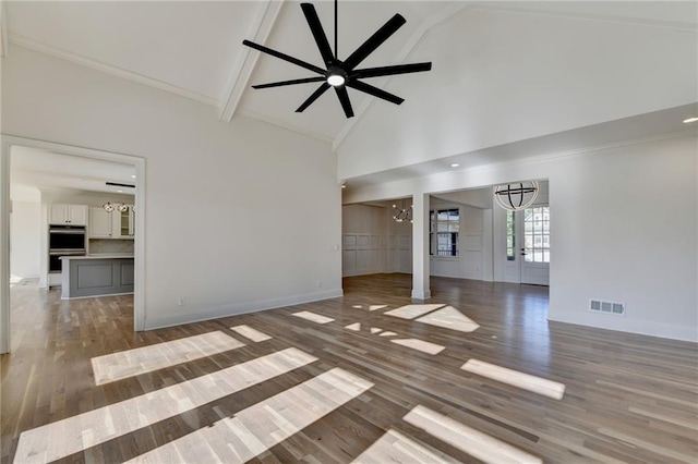 unfurnished living room featuring baseboards, wood finished floors, high vaulted ceiling, and beamed ceiling