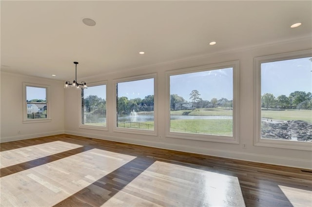 interior space featuring crown molding, baseboards, an inviting chandelier, and wood finished floors
