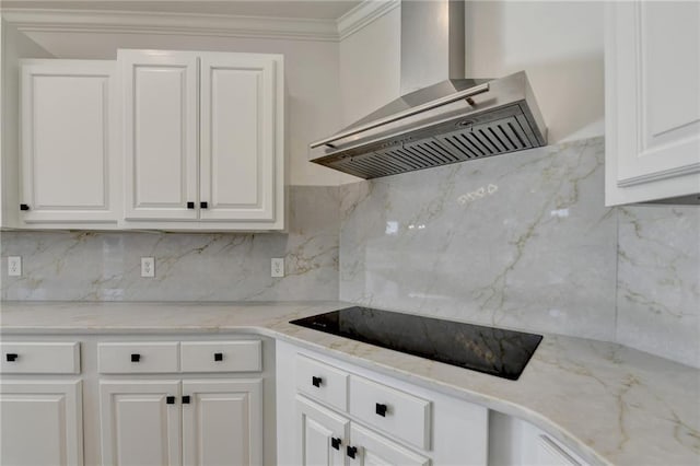 kitchen featuring wall chimney range hood, decorative backsplash, white cabinets, and black electric cooktop