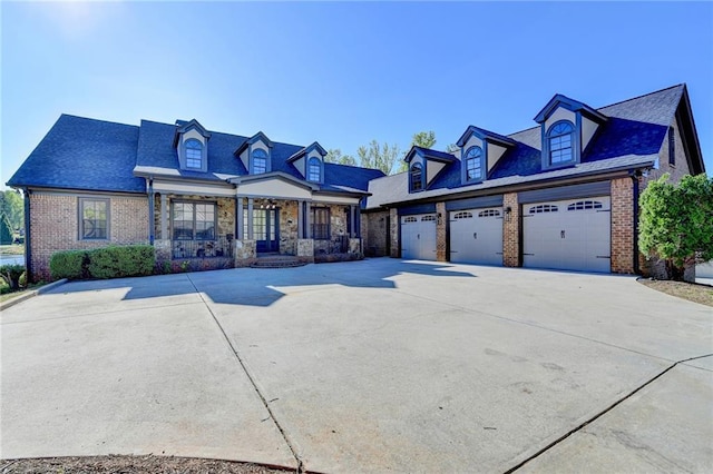 view of front of home with covered porch, concrete driveway, and brick siding